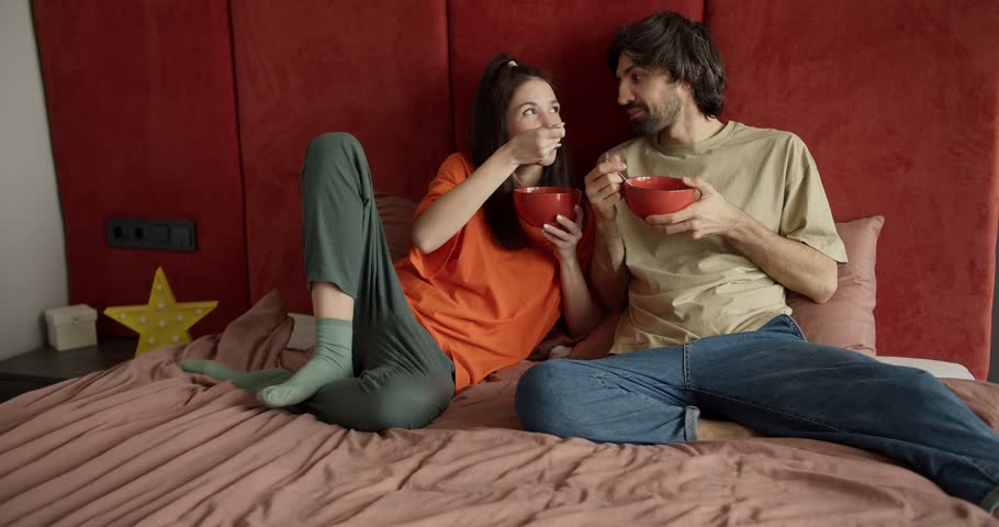 Happy Couple Enjoying Breakfast in Bed with Cornflakes and Milk Royalty-Free Stock Footage #1104046343
