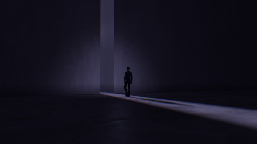 A darkened scene where we see a man walking towards a bright light coming from a tall opening in a huge stone marbled wall. Royalty-Free Stock Footage #1104052633