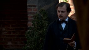 RICHMOND - SUMMER 2022 - Actor portrayal of American macabre poet and author Edgar Allen Poe - thinking and writing in an ancient memorial garden. deep in thought, composing into a book.  Manuscript. - Powered by Shutterstock - Get 15% off with code: PIKWIZARD15