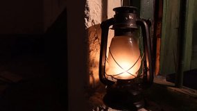Kerosene lanterns of warm yellow light hang on the walls. Hurricane lamp warm light reflected on a wall. Kerosene lamp Close up views 4k video.
