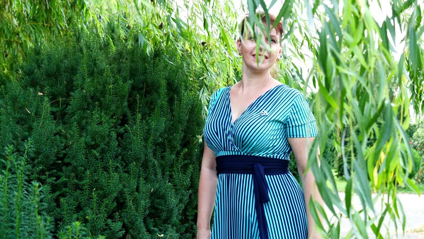 Woman hiding behind flexible willow branches