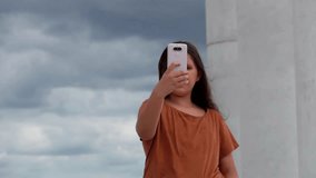 Smiling girl with long dark hair looking at smartphone. High quality FullHD footage