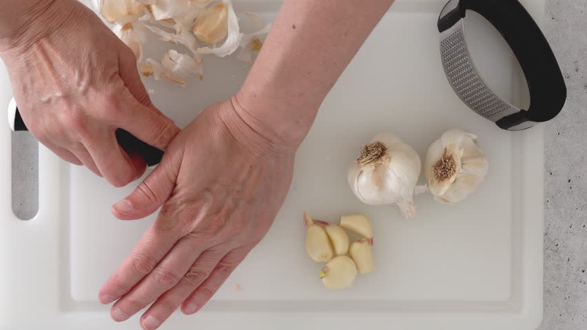 Bulbos Del Ajo En La Prensa De La Tabla De Cortar Y De Ajo Foto de