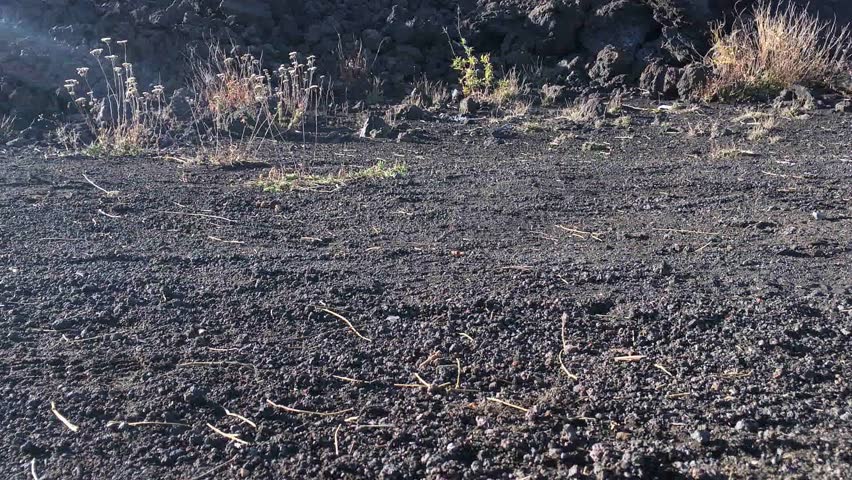 Sicily mount Etna detail of legs and boots on a lava stone path