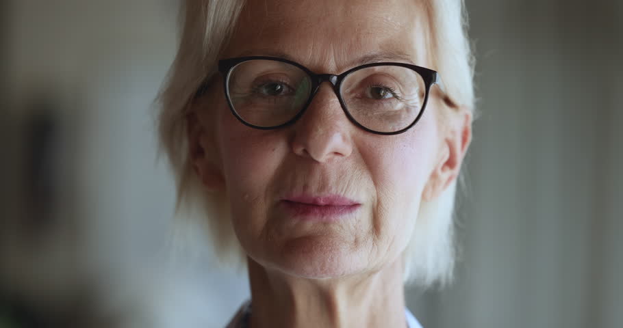 Close up crop face view happy mature female in glasses look at camera, revealing wide toothy smile, advertise eyesight vision check up or dental clinic professional services. Businesswoman portrait Royalty-Free Stock Footage #1104073383