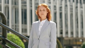 Serious redheaded businesswoman looking at the camera with arms crossed