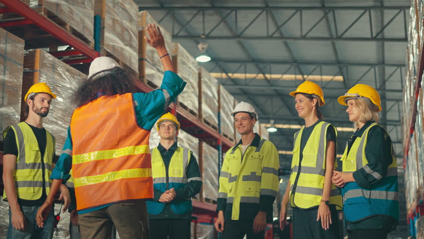 Team of factory workers celebrate a great success by putting hands together in the retail warehouse full of shelves. Royalty-Free Stock Footage #1104076557