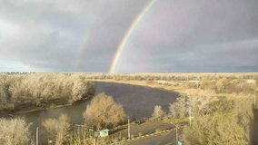Ural river and rainbow in the sky. Hand held video of the rainbow, river and horizon. 