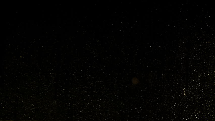 Rain running down the glass during night. A view of wet glass behing night heavy storm.