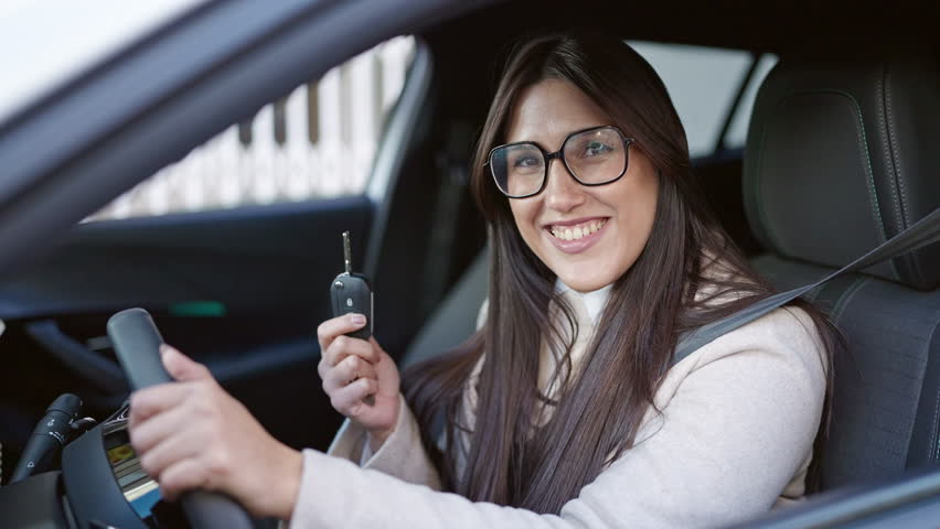 Young beautiful hispanic woman smiling confident holding key of new car at street