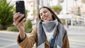 Young beautiful hispanic woman smiling confident having video call at street
