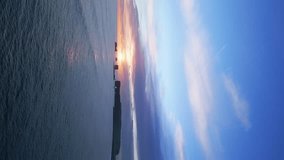 Vertical video: Arctic reynisfjara black sand beach on spectacular nordic landscape with sunset and ocean waves crashing on shore. Aerial view of icelandic coastline and natural scenery. Slow motion. - Powered by Shutterstock - Get 15% off with code: PIKWIZARD15