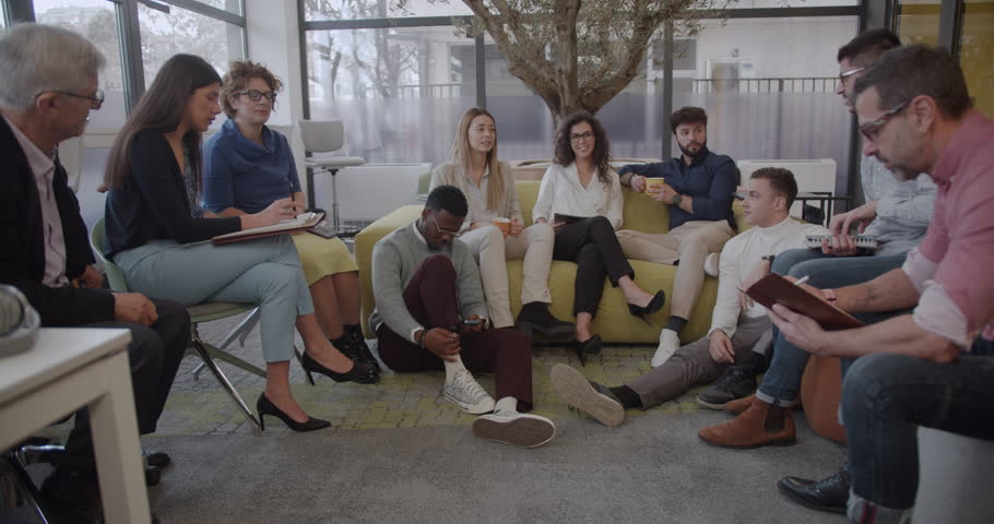 Large group of diverse people having a brainstorming meeting in the lounge area, trucking movement, wide shot, modern office space Royalty-Free Stock Footage #1104091449