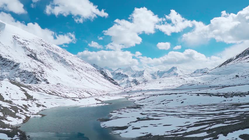 Beautiful view of snow covered mountains and river as seen from Shinkula top during summer. Shinku La Pass connects Ladakh and Himachal Pradesh. High Himalayan mountain pass on 16,580 feet. Royalty-Free Stock Footage #1104093907