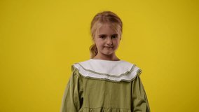 4k slow motion video of one kid who is surprised over yellow background.