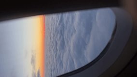 View of sunrise and heavy clouds from airplane window. Vertical video - Powered by Shutterstock - Get 15% off with code: PIKWIZARD15