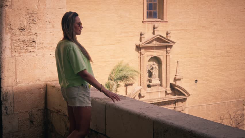 The girl will look from the balcony at the panorama of the city of Valencia