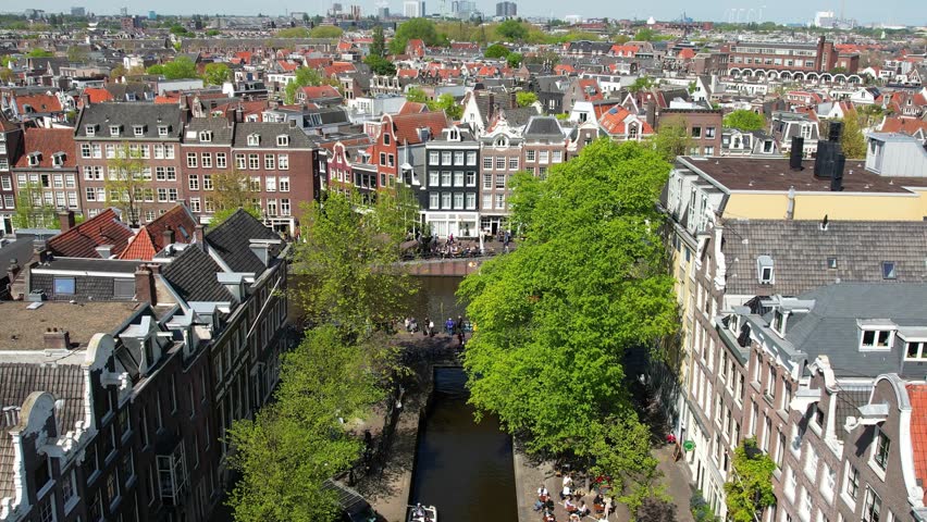 Amsterdam canals, streets and landmarks. Old centre aerial view. Famous places to see in Netherlands. Sunny summer day in Amsterdam, citybreak destination in Holland, establishing shot Royalty-Free Stock Footage #1104111561