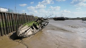 orbit of old rusty shipwreck stuck in mud against quayside at Fleetwood Docks, Lancashire, UK