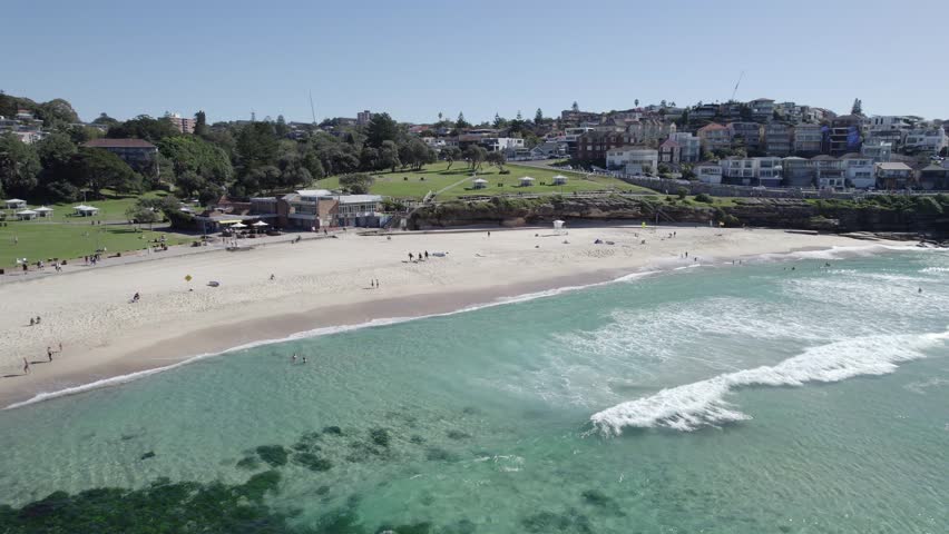 Bronte Beach With Tourists Enjoying On A Sunny Day In Sydney, Australia - aerial pullback