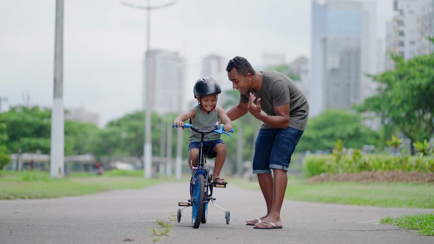 happy spending quality time together outdoors with his son. Kid riding bike having fun with his father
 Royalty-Free Stock Footage #1104122759