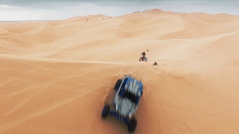 Group of four wheel drive vehicles competing on dunes. Aerial view of ATV buggy sport car riding fast by sand dunes. Extreme sport outdoor hobby on weekend day. Sport recreation concept for men 4K Video de stock