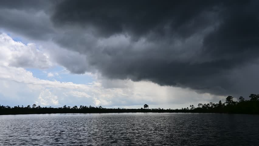 Time lapse of storm clouds forming in unsettled atmosphere above Pine Glades Lake in Everglades National Park, Florida 4K.