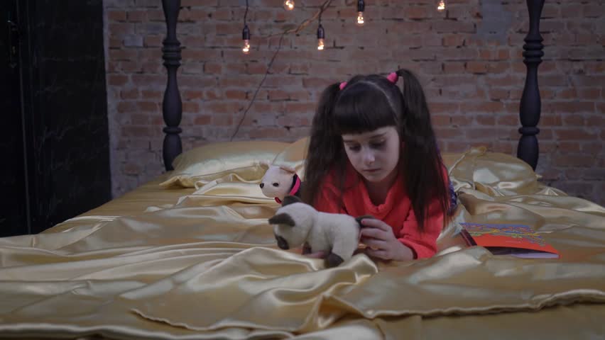 4K child sitting on the bed in the bedroom a cheerful kid in the children