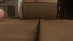 Worker closes cardboard box with adhesive tape from dispenser closeup. Person packs container in postal warehouse - Powered by Shutterstock - Get 15% off with code: PIKWIZARD15