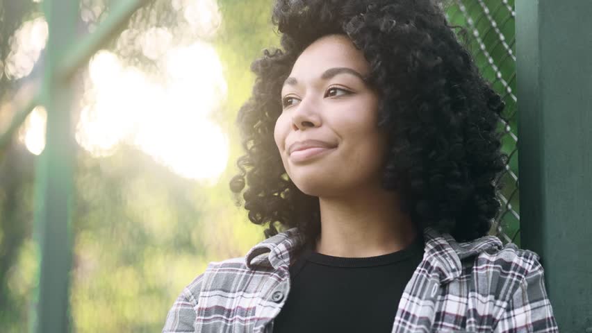 Close up portrait of smiling carefree young African American woman feeling absolutely happy and satisfied enjoying great day Self confidence curly girl looking at camera feel proud achievement alone
