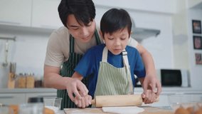Happy family. Asian father and son having cooking or baking in the kitchen enjoying weekend at home together. Father teaching little son rolling out dough with wooden rolling pin on table with flour - Powered by Shutterstock - Get 15% off with code: PIKWIZARD15