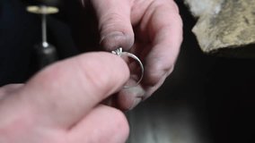 Gold wedding ring craft by goldsmith, isolated. Macro video. Craft jewelry making with professional tools. Process of ring polishing making handmade. 4k raw slow motion video