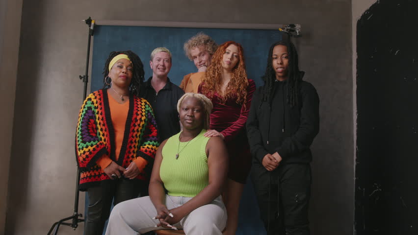 Handheld shot of six LGBTQIA queer people smiling and laughing against studio backdrop | Shutterstock HD Video #1104148063