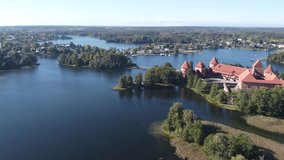 Castle houses and villas on the islands surrounded by blue water. Lake in Lithuania. Trakai Island Castle of Galve lake. SCO world heritage site. Drone video.