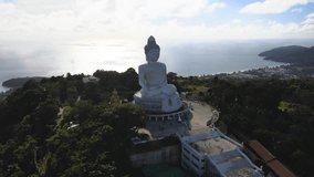 Drone video afternoon light sky and blue ocean are on the back of Phuket Big Buddha statue.white Phuket big Buddha is the one of landmarks on Phuket island Thailand.