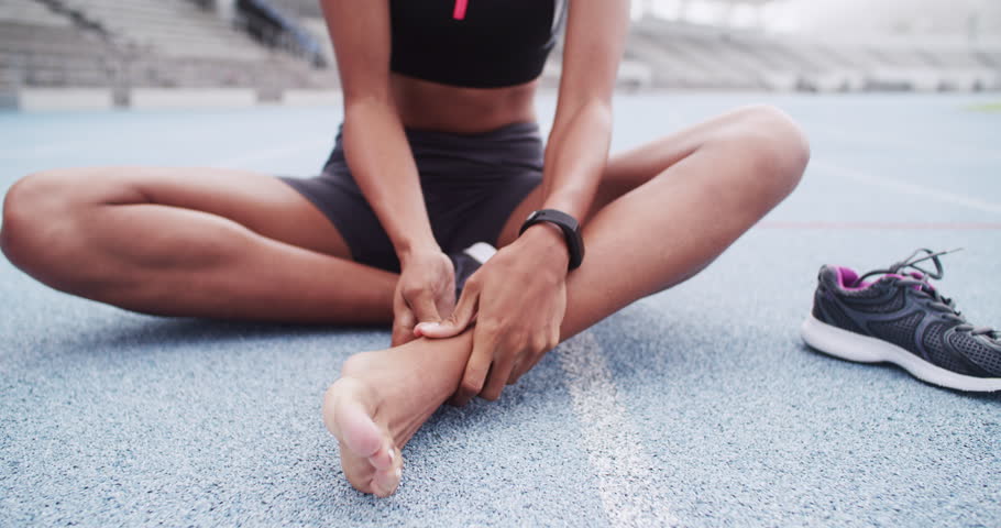 Sports, woman and runner with a foot injury in workout, exercise or running track in stadium. Female athlete, feet and pain in ankle, leg or body wellness in field, training performance and health Royalty-Free Stock Footage #1104163659