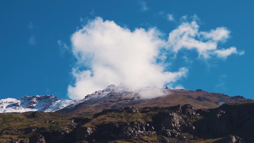 Clouds above the snow covered mountain peaks of Lahaul at Lahaul and Spiti District of Himachal Pradesh, India. Clouds cover the snowy mountain peaks of the Himalayas during the monsoon season.