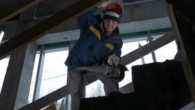 Building a house. Clip. A man in a special uniform with equipment works with metal.