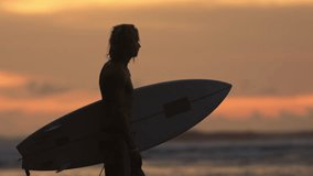 Silhouette profile of surfer man looking at epic view golden hour, side view male surfer concentrating and mind setting for training workout, thinking about upcoming surfing session training at sunset - Powered by Shutterstock - Get 15% off with code: PIKWIZARD15