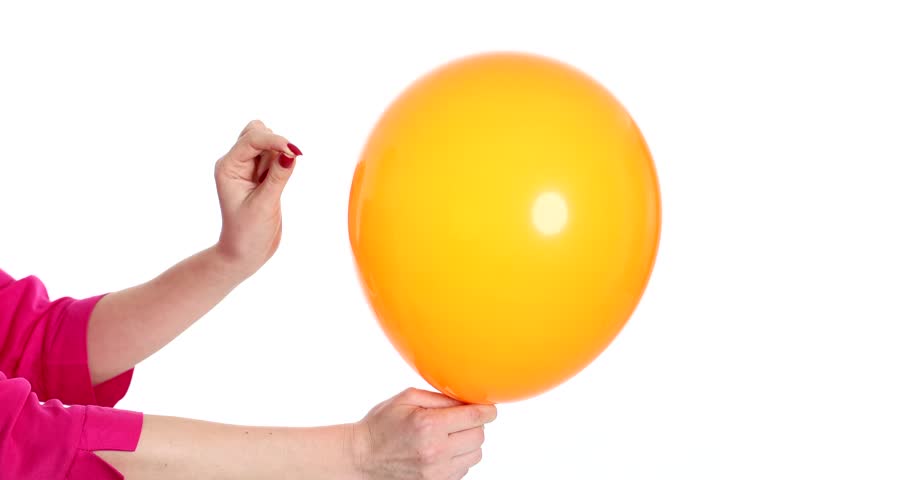 Hand popping an orange balloon with safety pin closeup on white background 4k movie Royalty-Free Stock Footage #1104168561