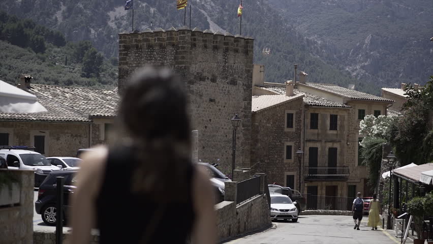 Rack focus video of a young girl walking by a rustic street in slow-motion