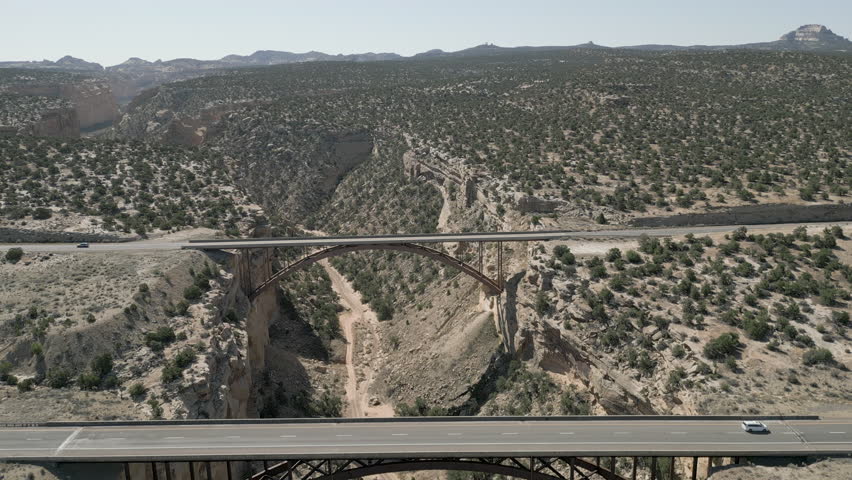 Aerial-Descending into Eagle Canyon while viewing the twin bridges of Interstate Freeway-70 spanning the canyon in light traffic.