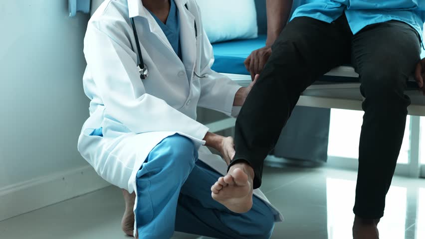 Male doctor orthopedist examining patient's leg in clinic. Royalty-Free Stock Footage #1104171431