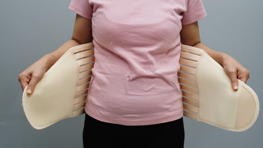 woman wearing lumbar support belts. pregnant and postnatal lumbar brace after surgery Royalty-Free Stock Footage #1104172457