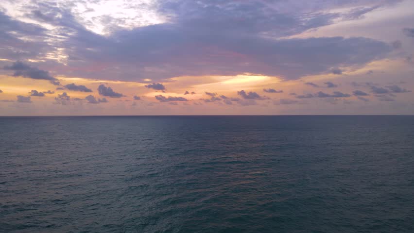 Ocean panorama. Dark orange clouds day to night sky. Dramatic sunset over storm clouds. Beautiful red color sky. Red purple orange blue pink sunset cloud background. Concept holiday in the tropics slo
