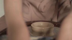 a female potter works behind a potter's wheel. close-up of the hand. clay product. High quality Full HD video recording