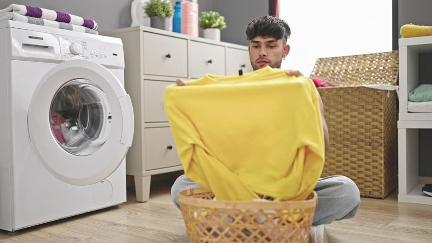 Two men couple washing clothes hugging each other at laundry room