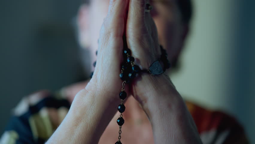 Catholic Religious older woman Praying the Rosary having HOPE and FAITH. Grateful Elderly senior person engaged in prayer at home Royalty-Free Stock Footage #1104184199