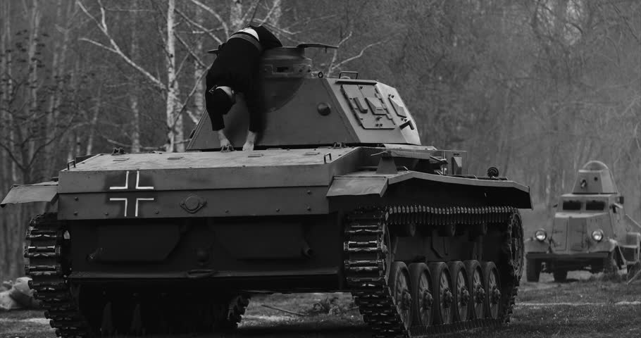 Re-enactor Dressed As Dead German Tank Crew Lies Slain on German Wehrmacht Light Panzer Tank In Reconstruction Of Battles World War Ii. After Battle. Black And White Video.