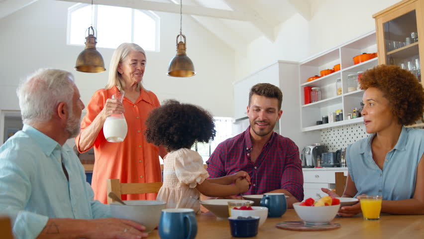 Multi-generation family at home enjoying breakfast sitting around table together - shot in slow motion Royalty-Free Stock Footage #1104187993